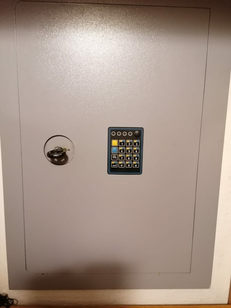 Cassaforte a muro grigia con tastiera elettronica e serratura a chiave